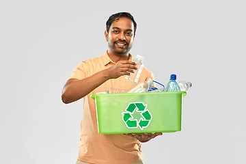 Image showing smiling young indian man sorting plastic waste