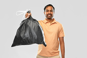 Image showing smiling indian man holding trash bag