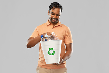 Image showing smiling young indian man sorting plastic waste