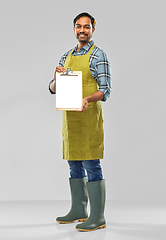 Image showing happy indian gardener or farmer with clipboard