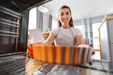 Image showing woman cooking food in oven at home kitchen