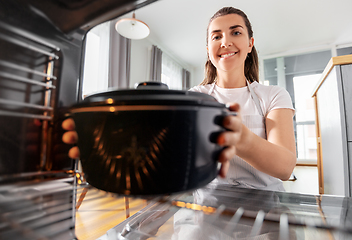 Image showing woman cooking food in oven at home kitchen