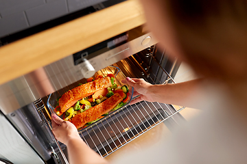 Image showing woman cooking food in oven at home kitchen