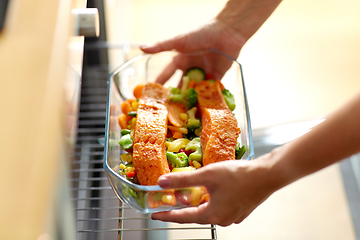 Image showing woman cooking food in oven at home kitchen