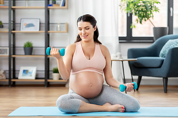 Image showing pregnant woman with dumbbells doing sports at home