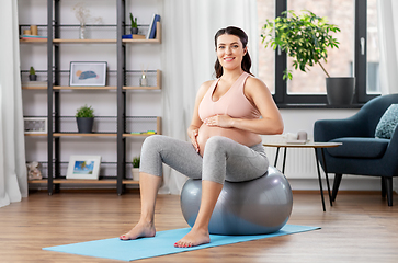 Image showing pregnant woman exercising on fitness ball at home