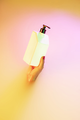 Image showing Close up female hand gesturing from the milk bath with soft glowing in neon light