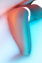 Image showing Close up female body in the milk bath with soft glowing in neon light