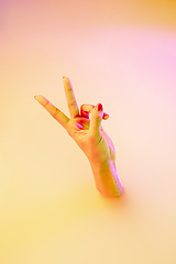 Image showing Close up female hand gesturing from the milk bath with soft glowing in neon light