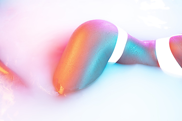 Image showing Close up female body in the milk bath with soft glowing in neon light