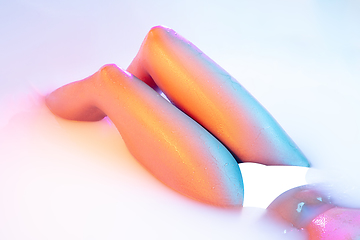 Image showing Close up female body in the milk bath with soft glowing in neon light