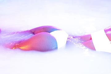 Image showing Close up female body in the milk bath with soft glowing in neon light