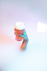 Image showing Close up female hand gesturing from the milk bath with soft glowing in neon light