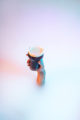 Image showing Close up female hand gesturing from the milk bath with soft glowing in neon light