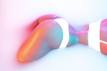 Image showing Close up female body in the milk bath with soft glowing in neon light