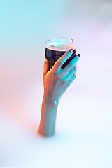 Image showing Close up female hand gesturing from the milk bath with soft glowing in neon light