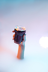 Image showing Close up female hand gesturing from the milk bath with soft glowing in neon light