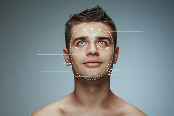 Image showing Beautiful male face with lifting up arrows isolated on grey background