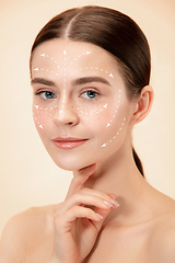 Image showing Beautiful female face with lifting up arrows isolated on studio background