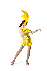 Image showing Beautiful young woman in carnival, stylish masquerade costume with feathers dancing on white studio background.