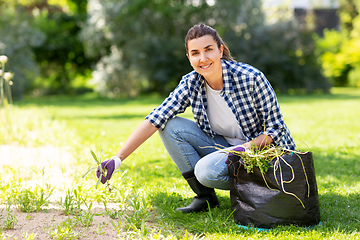 Image showing woman weeding flowerbed at summer garden