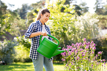 Image showing young woman watering flowers at garden