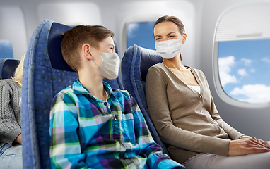 Image showing mother and son in masks traveling by plane