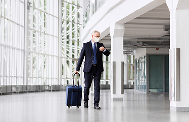 Image showing old businessman in mask with travel bag at airport
