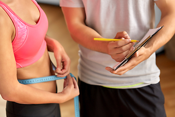 Image showing close up of woman with personal trainer in gym