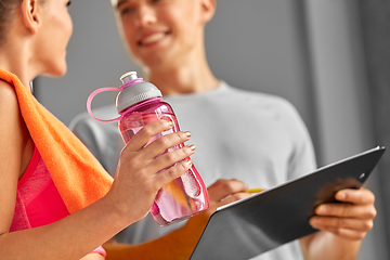 Image showing woman with water bottle and trainer in gym