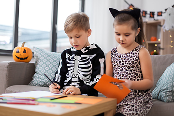 Image showing kids in halloween costumes doing crafts at home