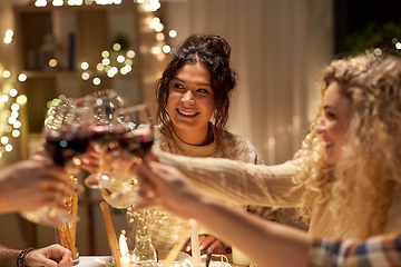 Image showing happy friends drinking red wine at christmas party