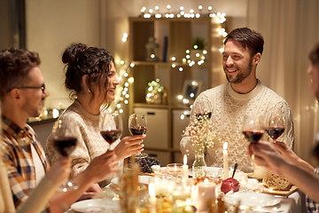 Image showing happy friends drinking red wine at christmas party