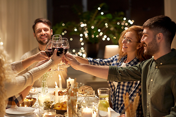 Image showing happy friends drinking red wine at christmas party