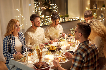 Image showing happy friends having christmas dinner at home