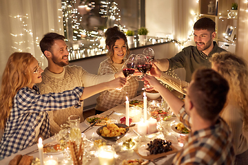 Image showing happy friends drinking red wine at christmas party