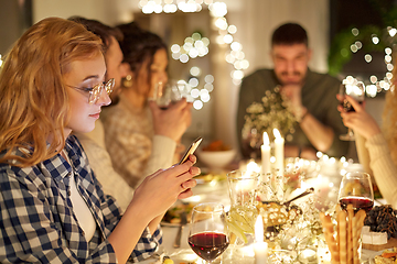 Image showing woman with smartphone at dinner party with friends