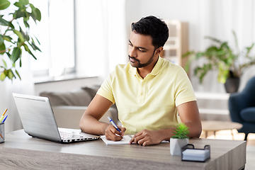 Image showing indian man with notebook and laptop at home office