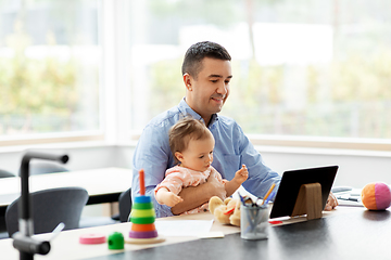 Image showing father with baby working on tablet pc at home