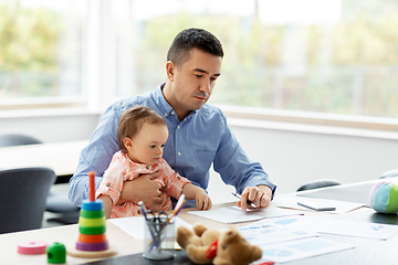 Image showing father with baby working at home office
