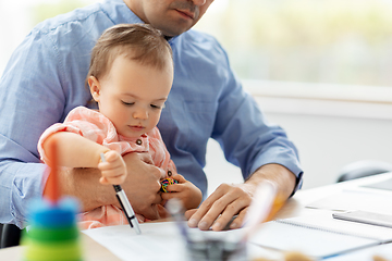 Image showing father with baby working at home office