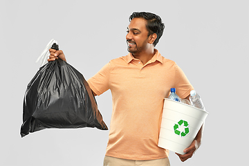 Image showing smiling indian man sorting paper and plastic waste