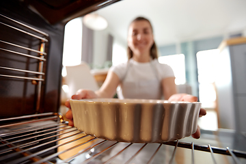 Image showing woman cooking food in oven at home kitchen