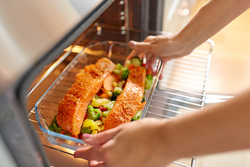 Image showing woman cooking food in oven at home kitchen