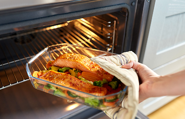 Image showing woman cooking food in oven at home kitchen