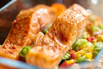 Image showing salmon fish in baking dish on kitchen table