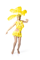 Image showing Beautiful young woman in carnival, stylish masquerade costume with feathers dancing on white studio background.