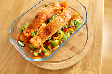 Image showing salmon fish in baking dish on kitchen table