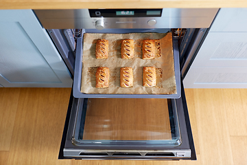 Image showing baking tray with jam pies in oven at home kitchen