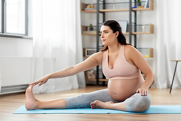 Image showing happy pregnant woman doing sports at home